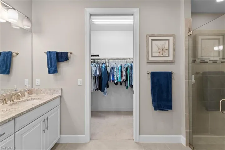 Bathroom featuring tile patterned flooring, vanity, and a shower with shower door