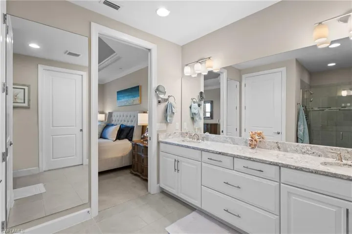 Bathroom featuring vanity, a shower with shower door, and ornamental molding