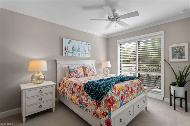 Bedroom featuring light carpet, ceiling fan, and ornamental molding