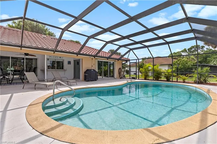 View of pool featuring ceiling fan, glass enclosure, and a patio