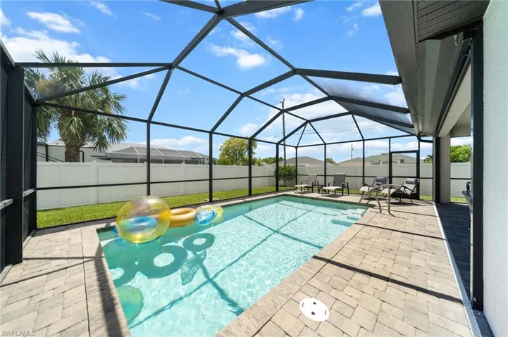 View of swimming pool featuring a sunroom, a patio, and glass enclosure