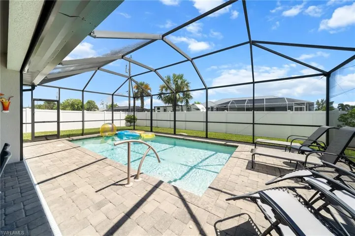 View of pool with a sunroom, a patio area, a fenced backyard, and a lanai
