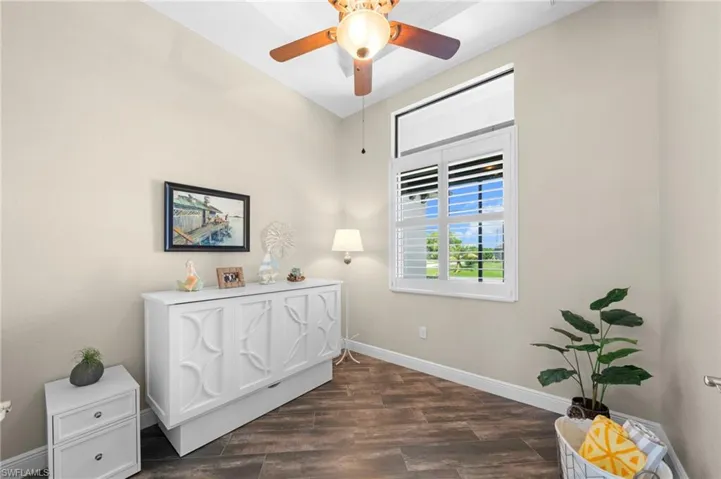 Living area with dark wood finished floors and a ceiling fan