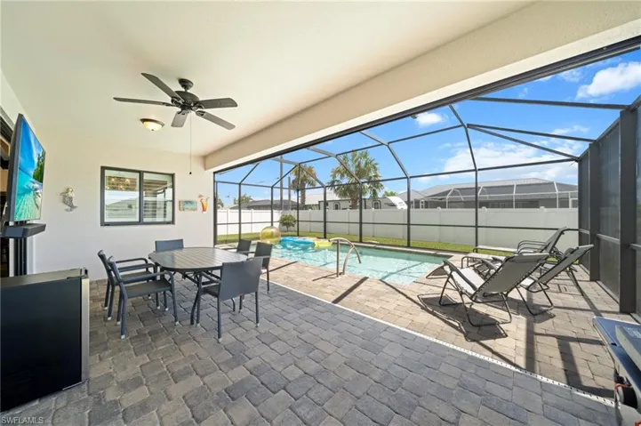 View of patio / terrace featuring a sunroom, glass enclosure, ceiling fan, and outdoor dining space