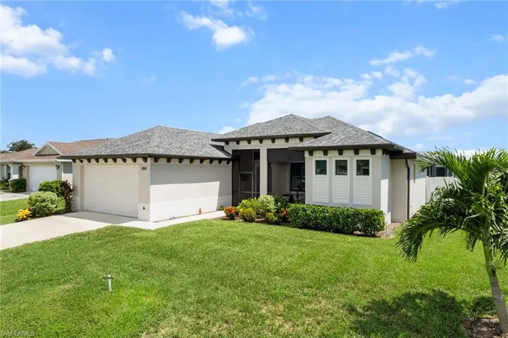 Prairie-style home featuring a garage, a front yard, and stucco siding