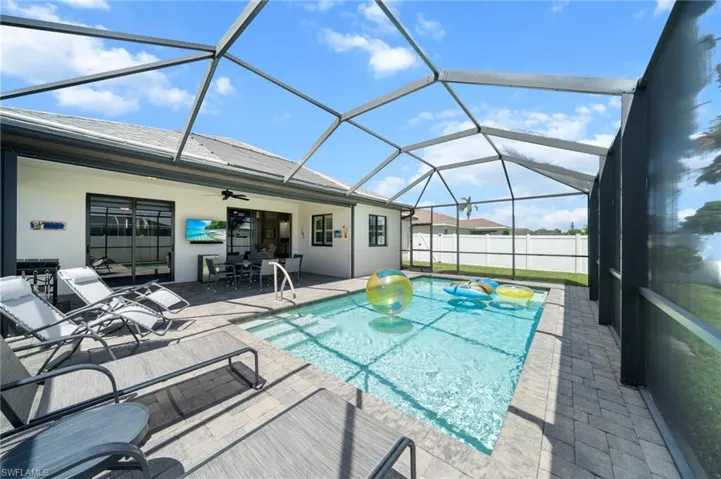 View of swimming pool with a sunroom, a patio area, ceiling fan, and a lanai