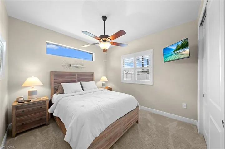 Bedroom with carpet, ceiling fan, and a closet
