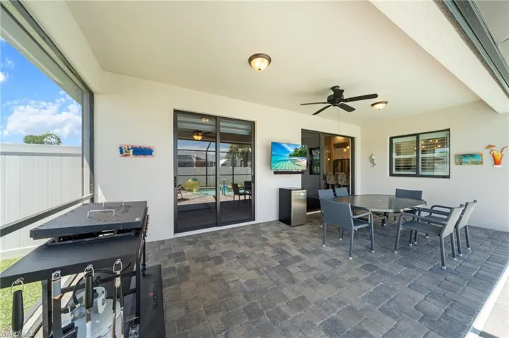 View of patio with outdoor dining area and a ceiling fan