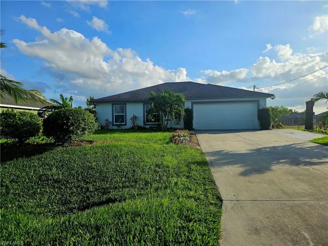 Ranch-style house featuring a garage and a front yard