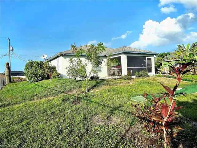 Back of house featuring a sunroom and a yard