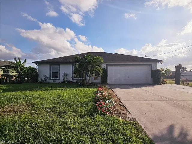 Ranch-style house with a garage and a front yard