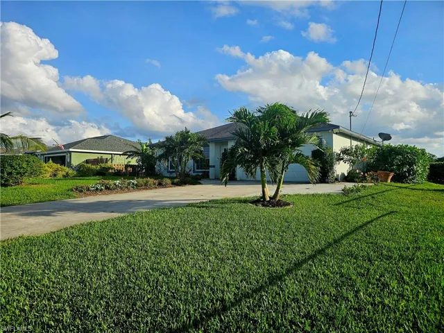 View of front facade featuring a garage and a front yard