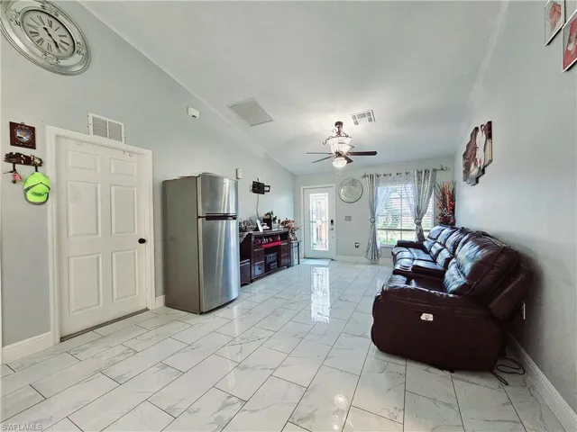 Living room featuring vaulted ceiling and ceiling fan