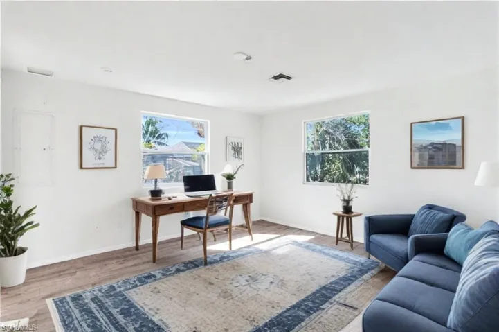 Virtual Staged- Bedroom/Office space featuring light wood-type flooring and a wealth of natural light - VIRTUALLY ENHANCED