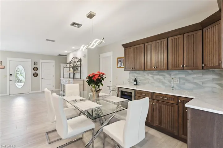 Dining area with light hardwood / wood-style floors and beverage cooler