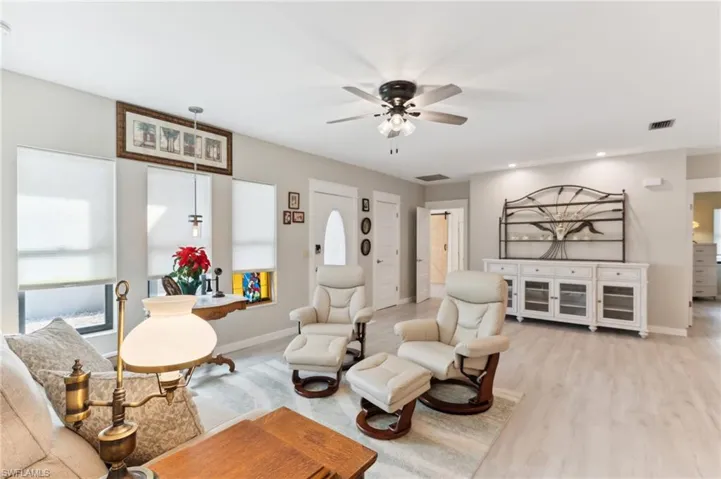 Living room with ceiling fan and light hardwood / wood-style flooring