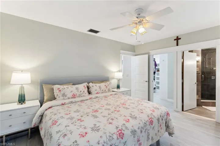 Bedroom featuring connected bathroom, light hardwood / wood-style floors, and ceiling fan