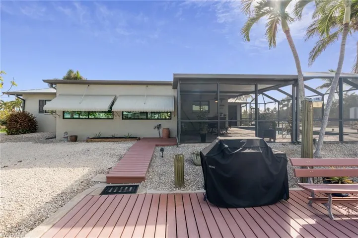 Deck featuring glass enclosure and a grill