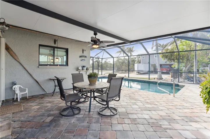 View of swimming pool featuring ceiling fan, a lanai, and a patio
