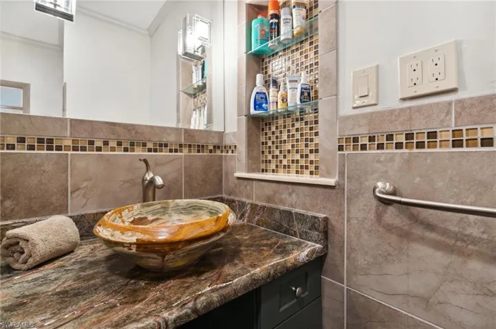 Bathroom with vanity, tile walls, and ornamental molding
