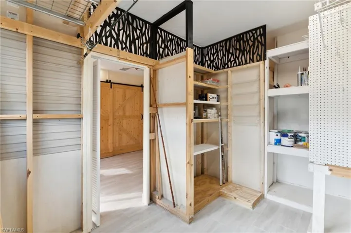 Unfurnished bedroom featuring a barn door and hardwood / wood-style floors