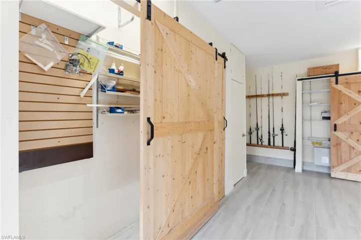 Corridor featuring a barn door and light hardwood / wood-style floors