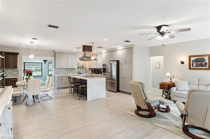 Living room with ceiling fan and light hardwood / wood-style floors