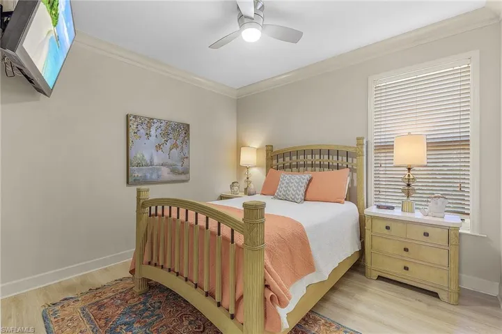 Room with crown molding, a ceiling fan, and wood-finish flooring