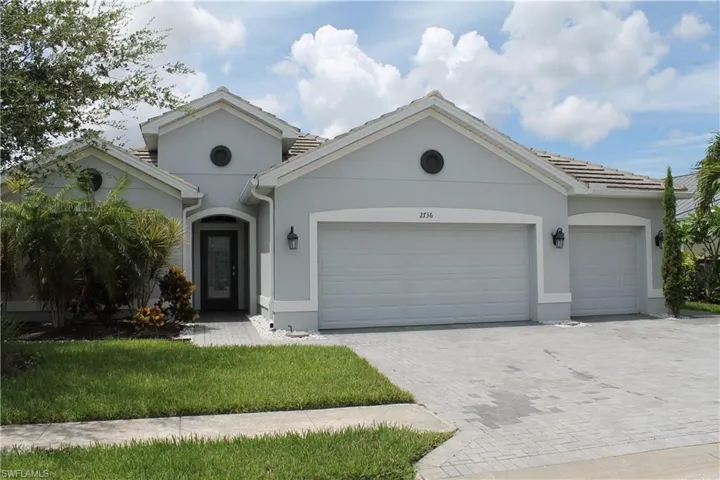 Stucco exterior with a tiled roof and multiple gables
