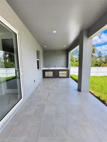 Covered patio featuring an outdoor kitchen with integrated sinks and stainless steel appliances