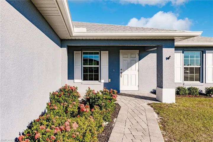 View of exterior entry with a lawn