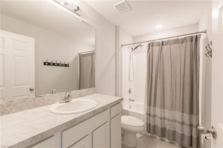 Full bathroom featuring tile patterned flooring, vanity, toilet, and shower / bath combo