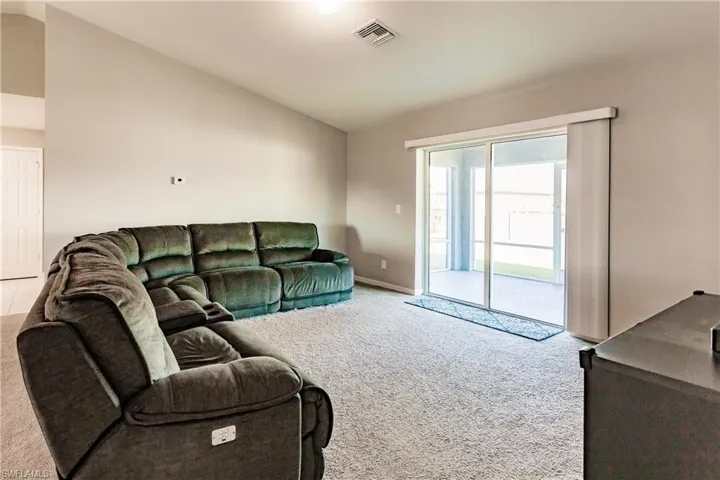Living room featuring carpet and lofted ceiling