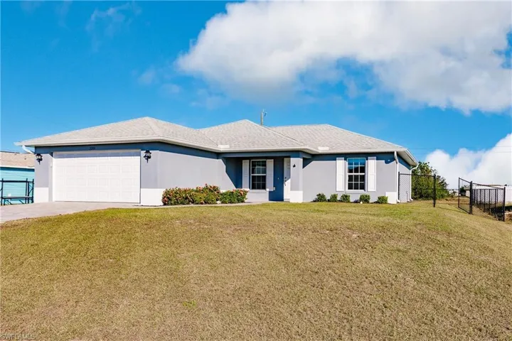 Ranch-style home featuring a front lawn and a garage