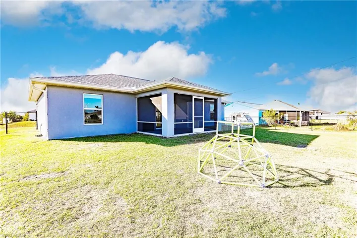 Rear view of property with a yard and a sunroom