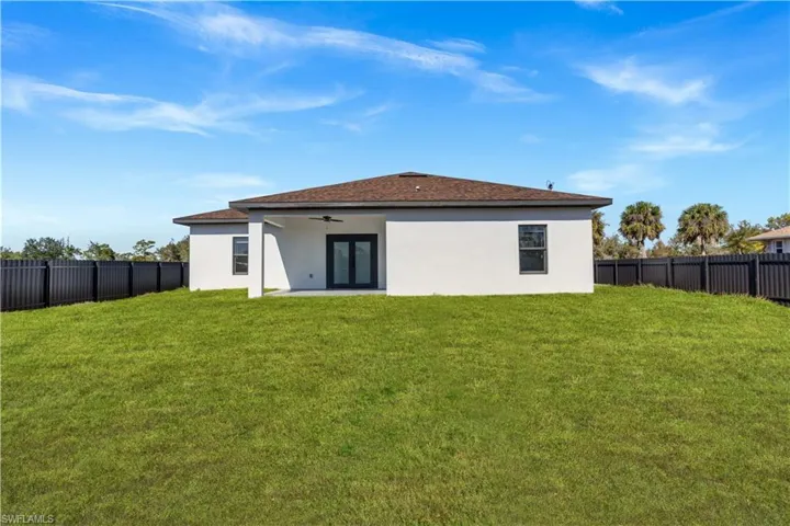 Rear view of house with a fenced backyard, ceiling fan, a patio area, stucco siding, and french doors