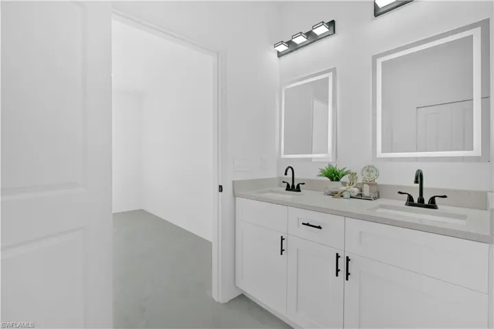 Full bathroom with double vanity and finished concrete flooring