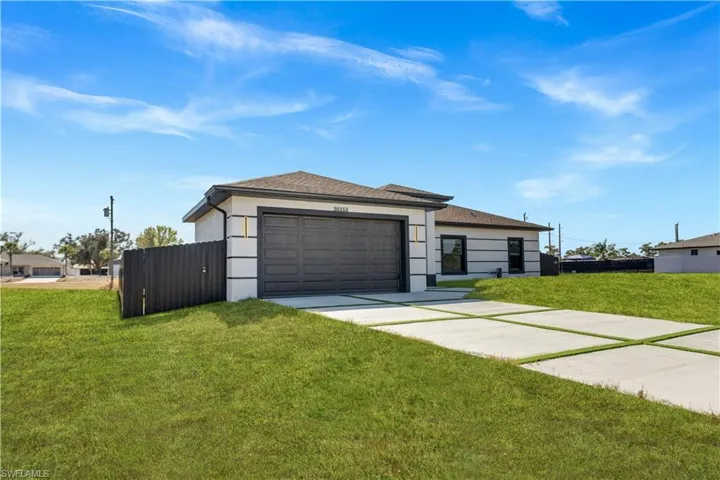 View of front of property featuring concrete driveway, a garage, a shingled roof, and stucco siding