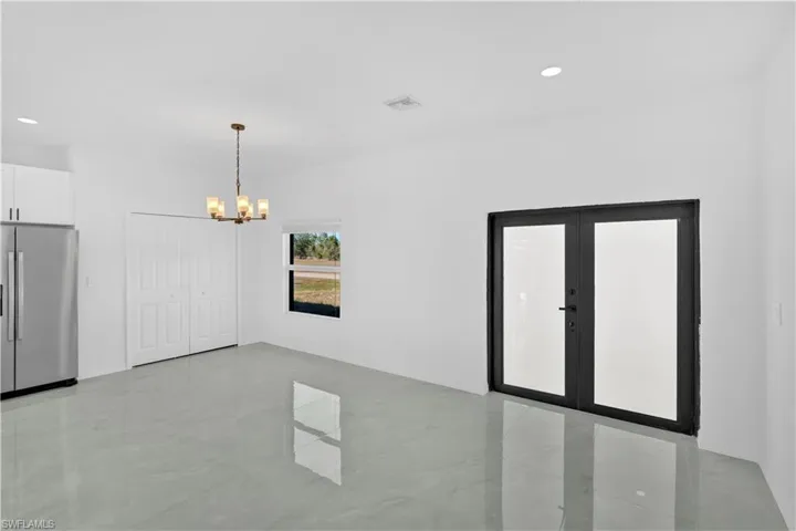 Unfurnished dining area featuring recessed lighting, french doors, and a chandelier