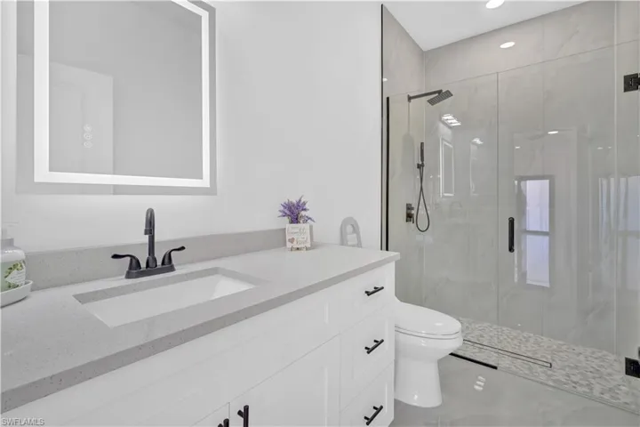 Full bath featuring vanity, a stall shower, and recessed lighting