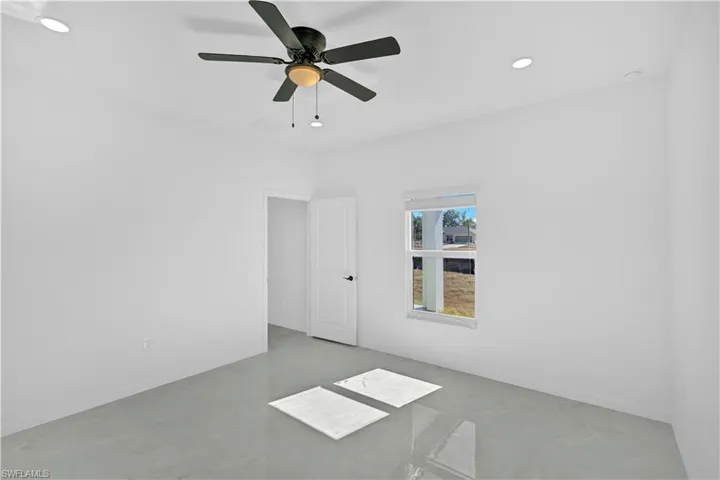 Spare room featuring recessed lighting, a ceiling fan, and concrete flooring