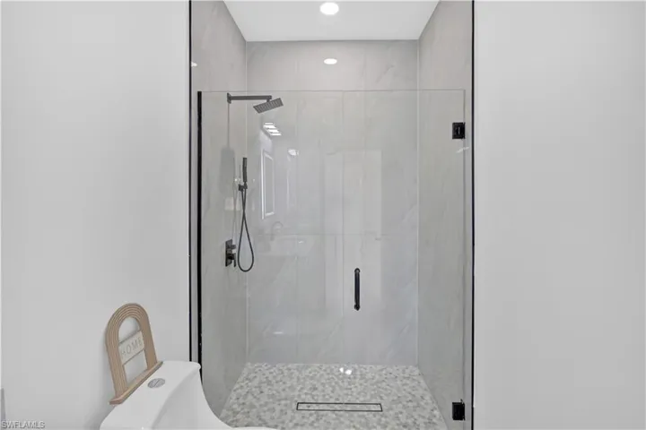 Bathroom featuring a marble finish shower and recessed lighting