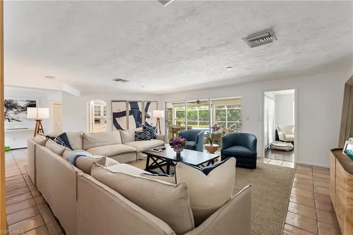 Living room with a textured ceiling and light tile flooring
