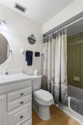 Bathroom featuring vanity, wood finished floors, and shower / tub combo