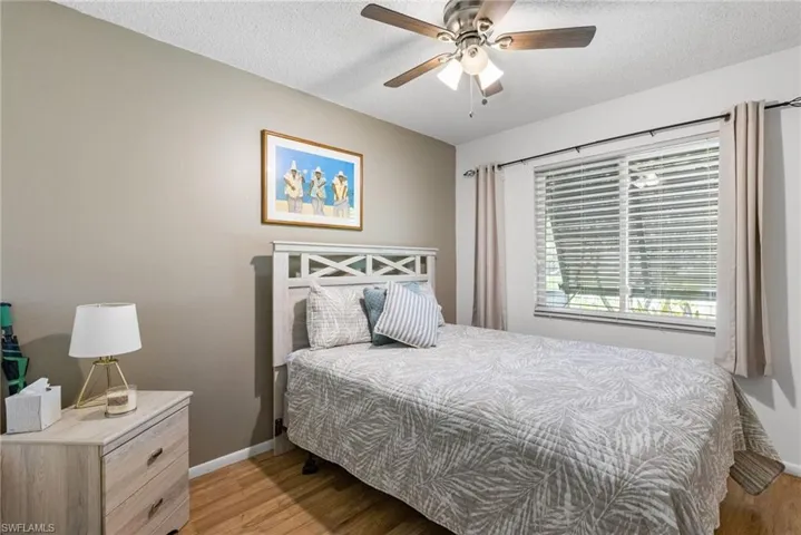 Bedroom featuring light wood-style flooring, a textured ceiling, and a ceiling fan