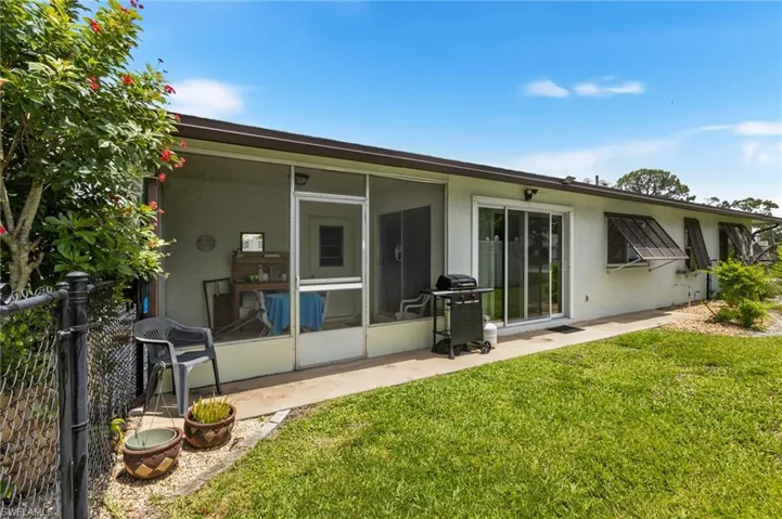 Back of house featuring stucco siding and a sunroom