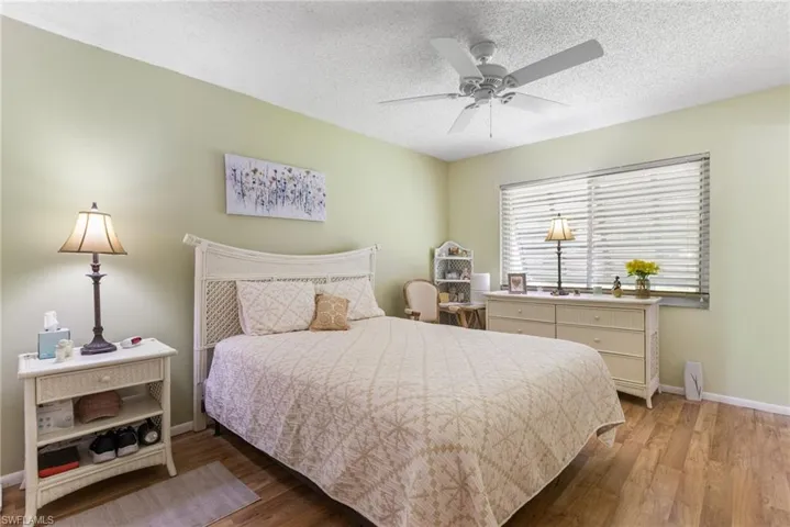 Bedroom featuring wood finished floors, a textured ceiling, and ceiling fan