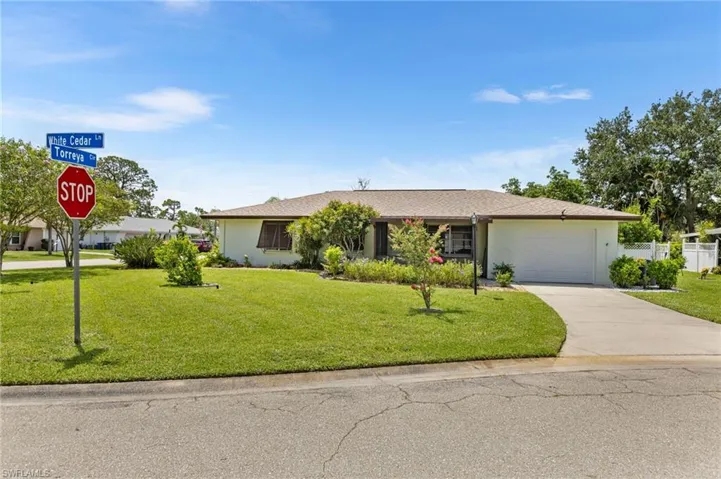 View of front of property with concrete driveway, an attached garage, and stucco siding
