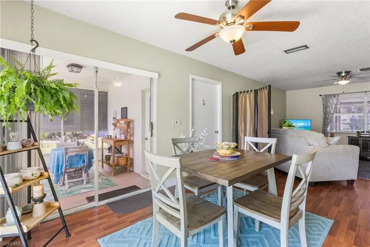 Dining space featuring a ceiling fan, wood finished floors, and a textured ceiling