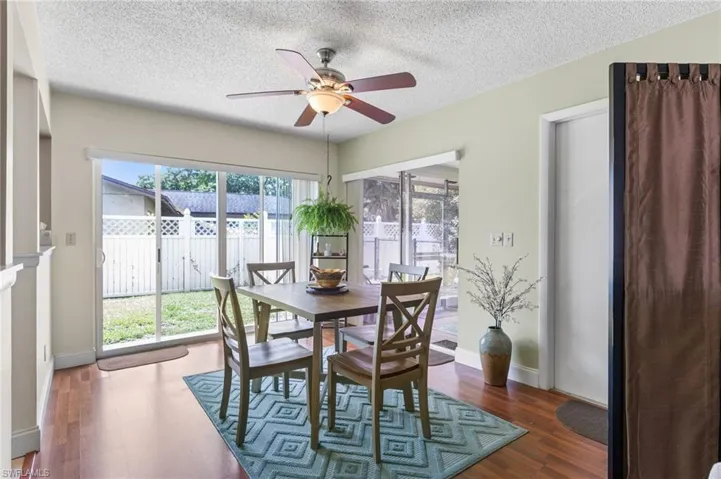Dining space featuring ceiling fan, wood finished floors, and a textured ceiling